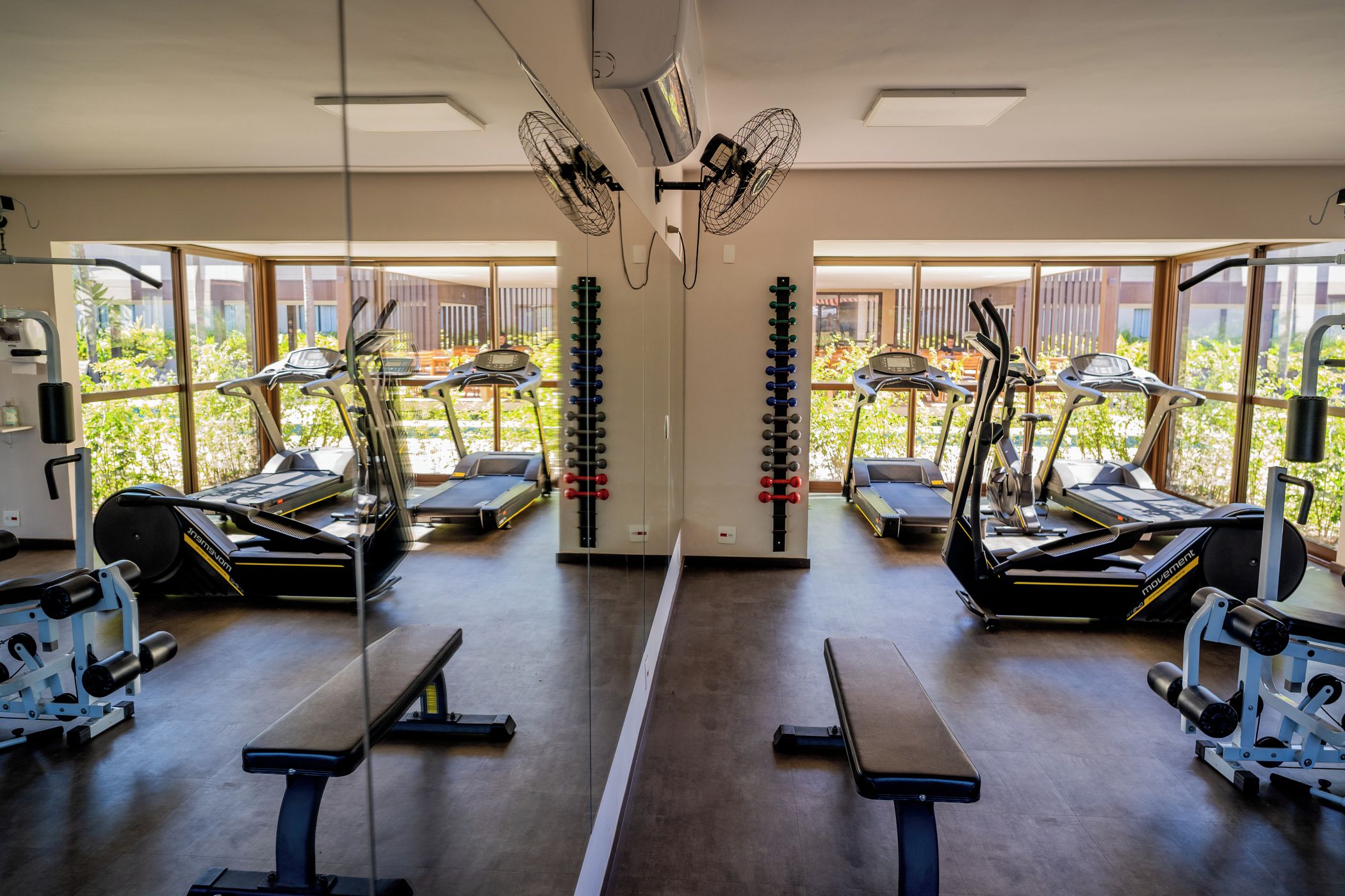 A gym with treadmills, elliptical machines, and weight machines.