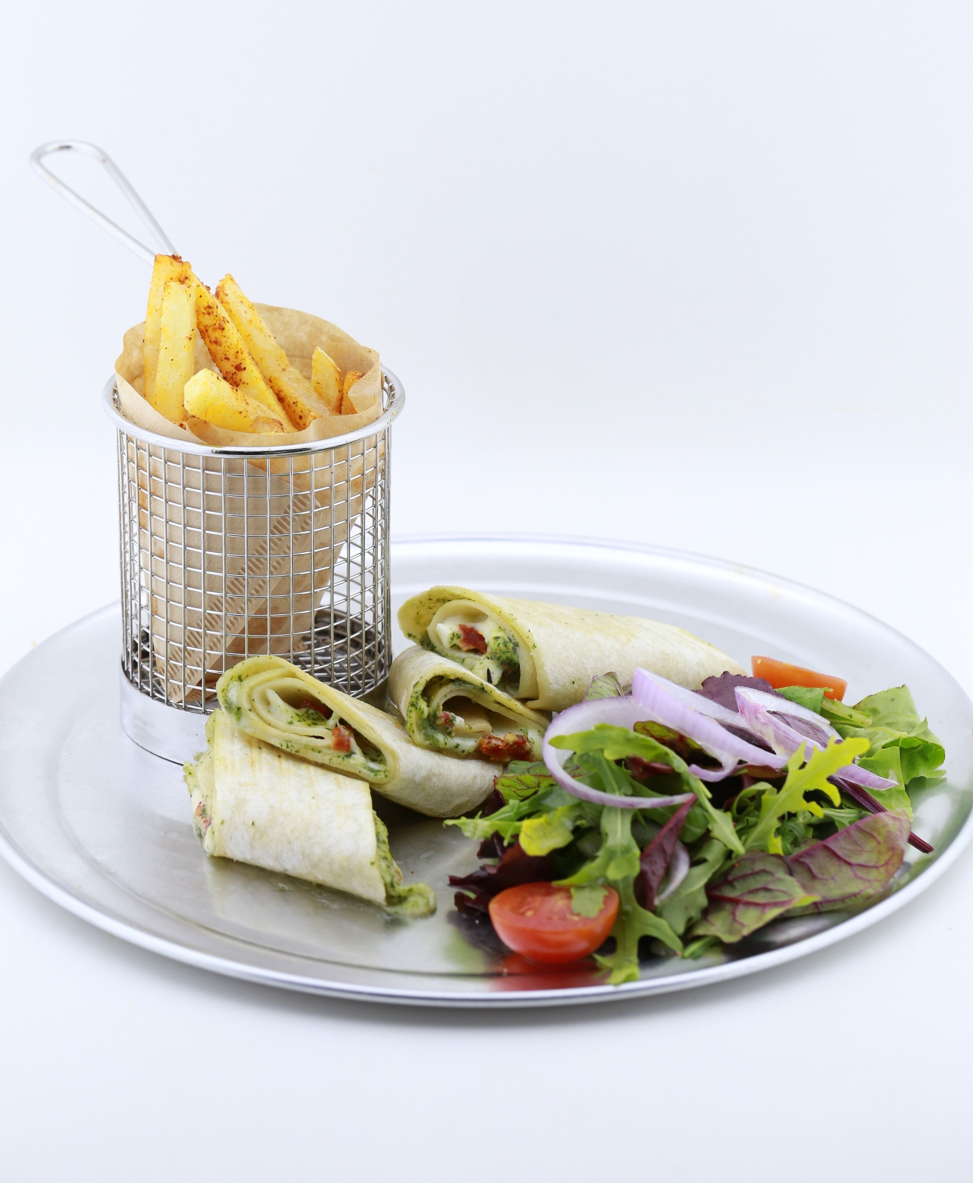 Un plato con ensalada, un wrap y una cesta de papas fritas.