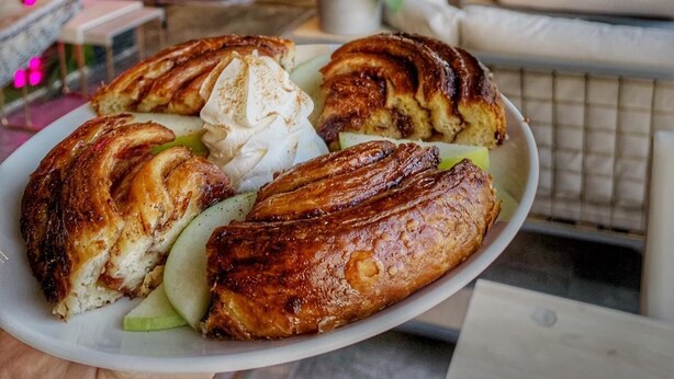 A plate of pastries with cream and apple slices, a hanging chair, and a sofa in a cozy indoor setting. - Royal Court Hotel (Ramallah)