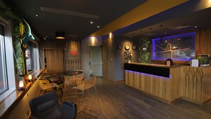 A modern interior with a reception desk, seating area, and decorative elements. - Royal Court Hotel (Ramallah)