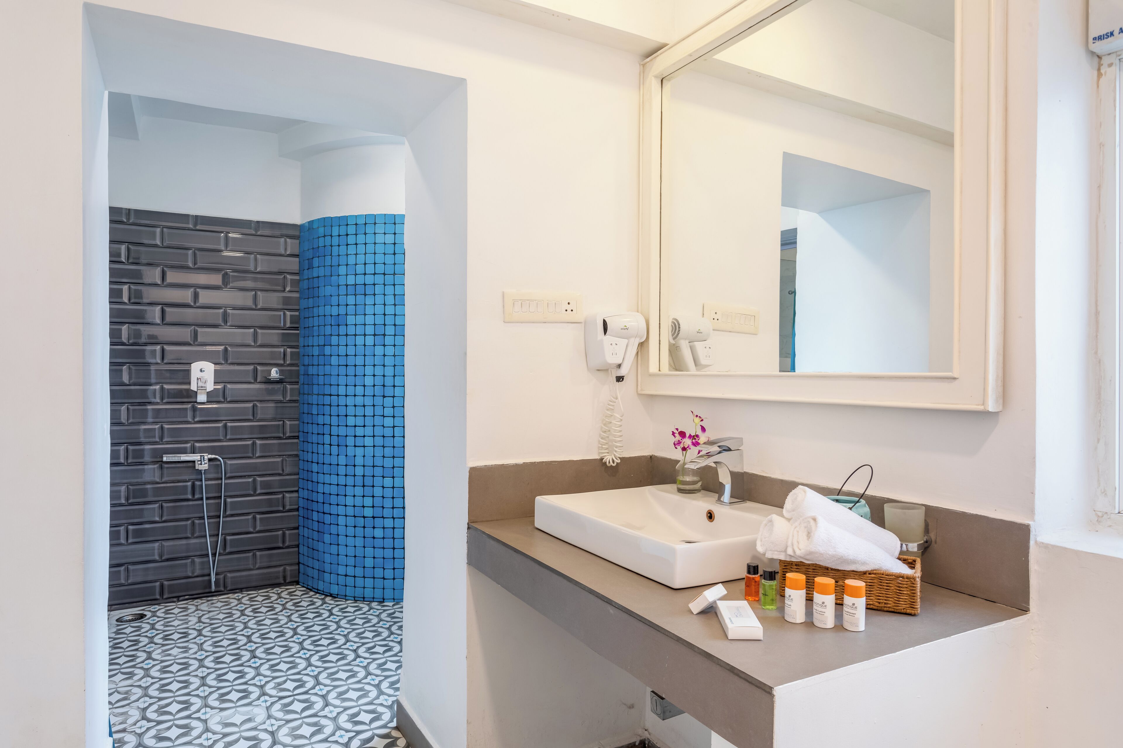 A modern bathroom with a shower, a sink, and a mirror.