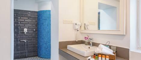 A modern bathroom with a shower, a sink, and a mirror.