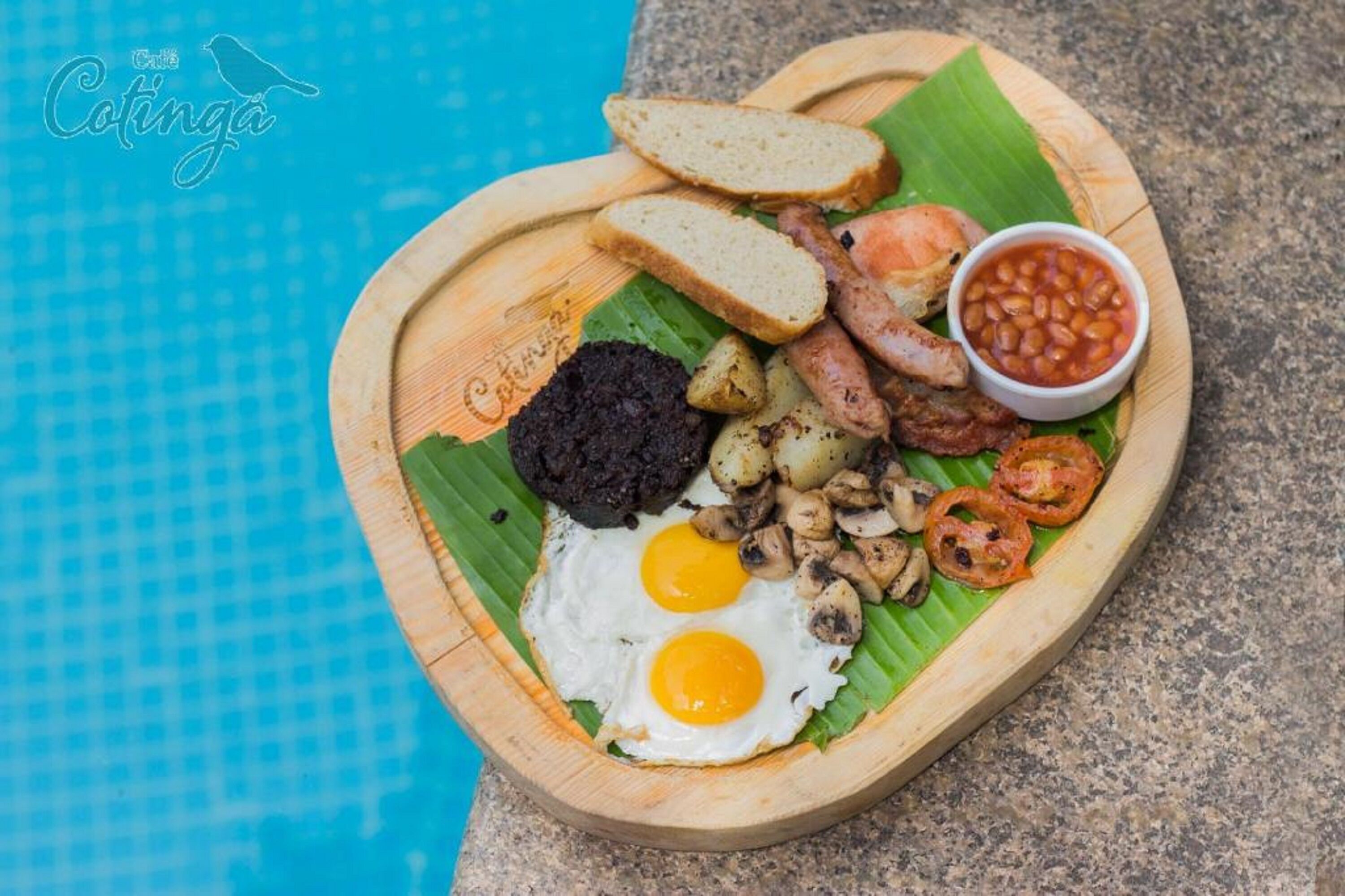 A breakfast plate with eggs, sausages, toast, beans, and potatoes.