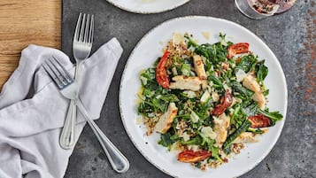 A plate of food with a fork and spoon on a table.