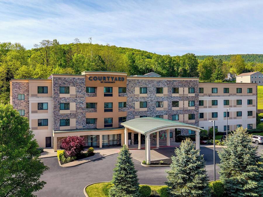 A Courtyard by Marriott hotel with a stone facade, multiple balconies, and a covered entrance.
