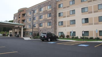 A multi-story hotel with a stone facade and a flat roof.