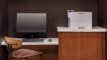 Un'area ufficio moderna con un monitor, una tastiera e una stampante su una scrivania.