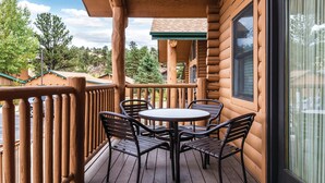 A wooden deck with a round table and four chairs, overlooking a scenic landscape. - WorldMark Estes Park (Estes Park)