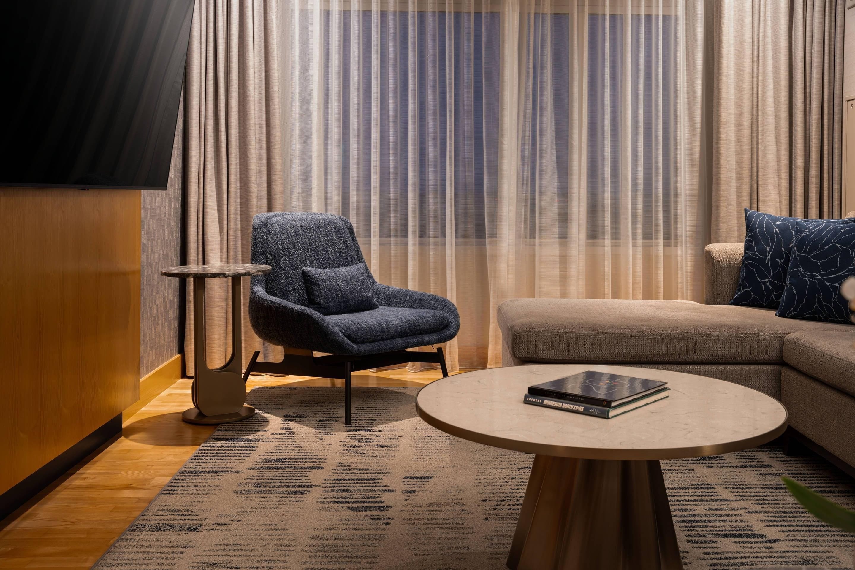 A modern living room with a sofa, a chair, a coffee table, and a floor lamp.