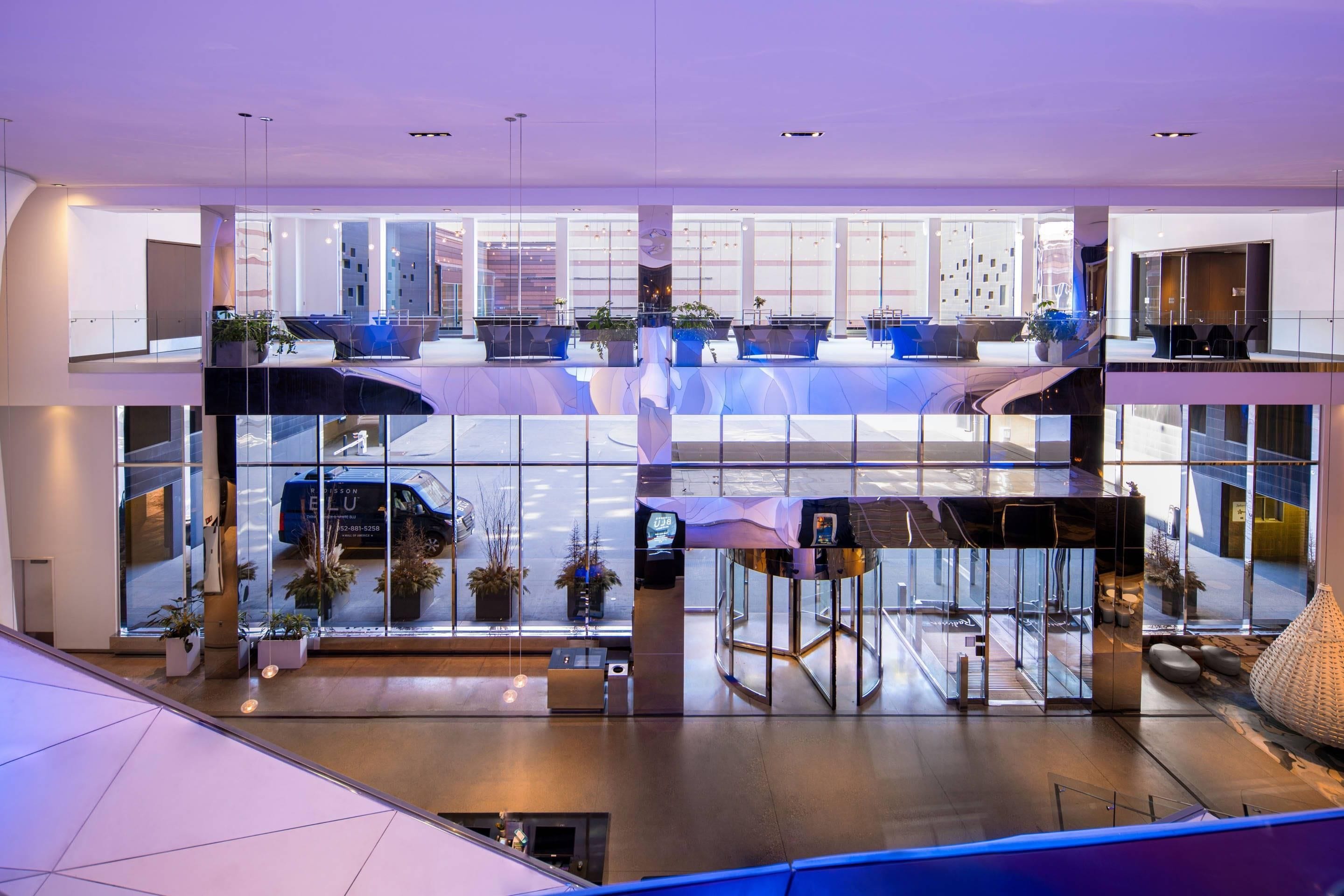A modern interior with glass walls, a reception desk, and seating areas.