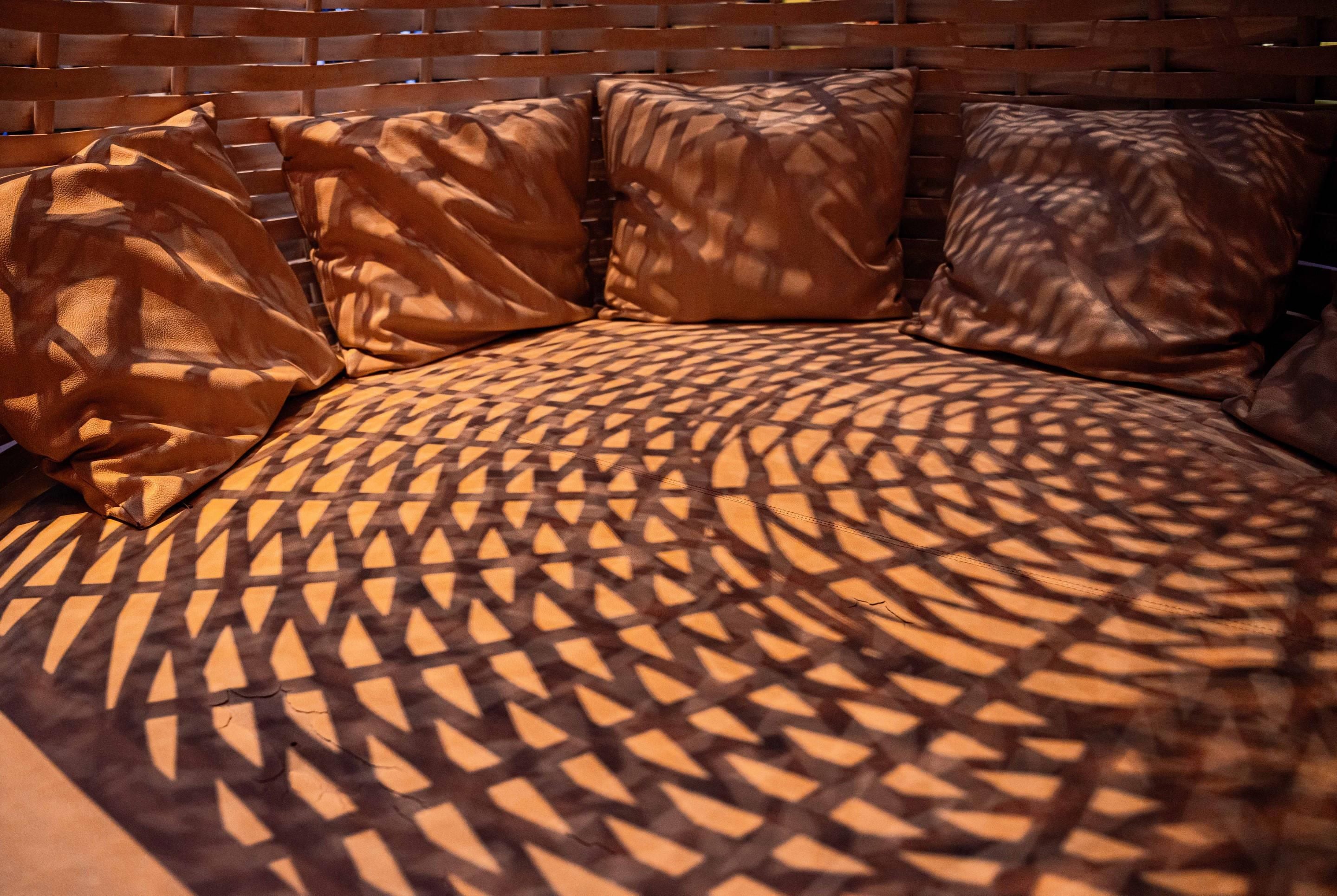 A bed with a patterned bedspread and multiple pillows.