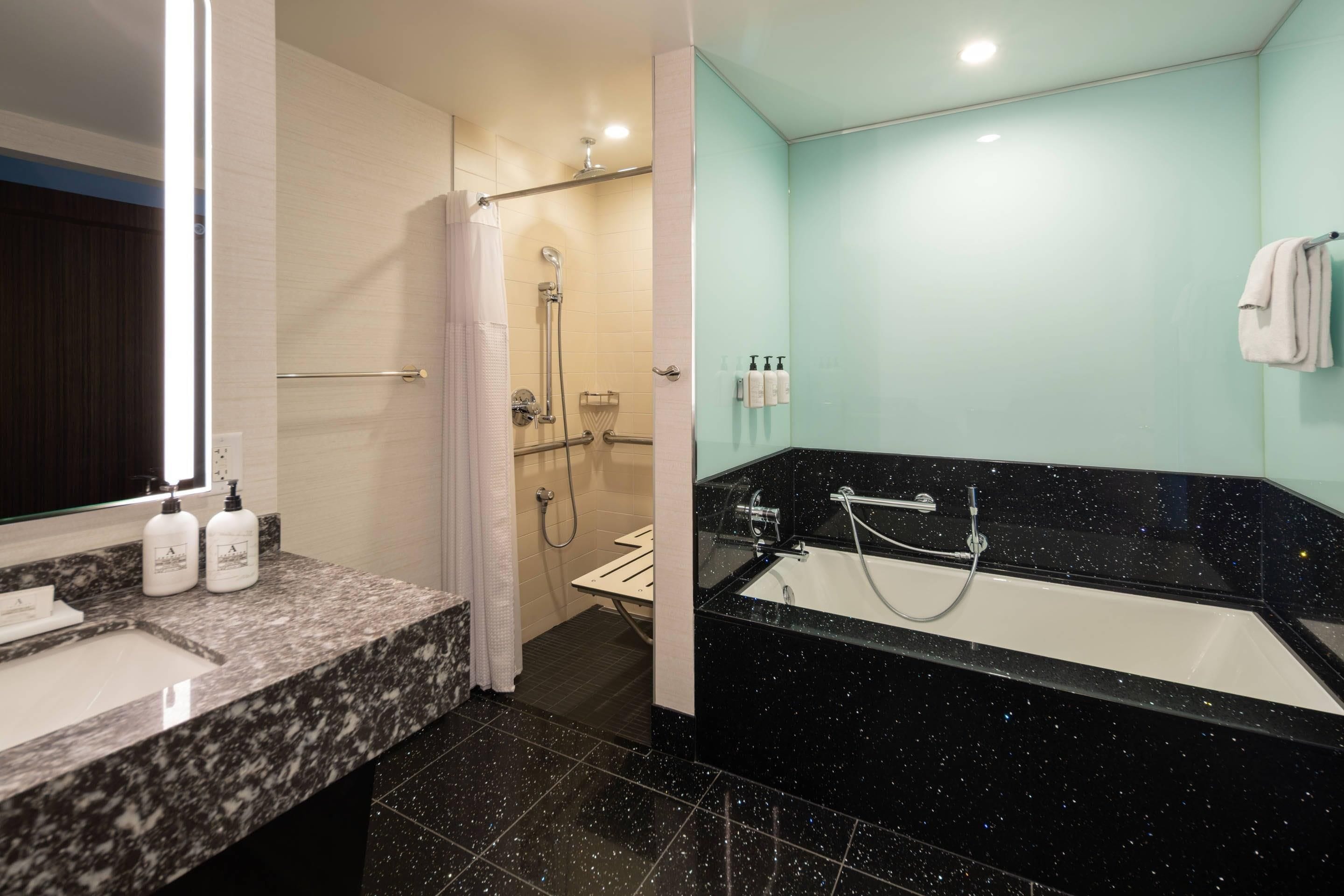Une salle de bain moderne avec un comptoir en marbre, une douche dotée d’une porte en verre et un espace séparé pour la baignoire.