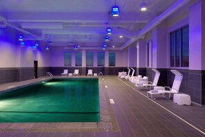 A swimming pool with lounge chairs and a ceiling with blue lights. - Radisson Blu Mall of America (Bloomington)