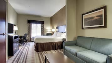 A hotel room with a bed, a desk, a chair, a sofa, and a television.