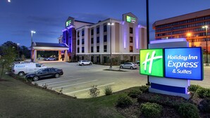 Un Holiday Inn Express & Suites con un amplio estacionamiento, una entrada al edificio y un cartel.