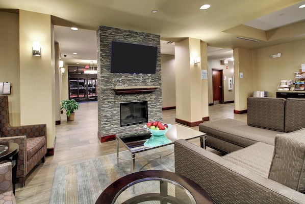 Un hall de hotel con chimenea, zona de estar y mostrador de recepción.