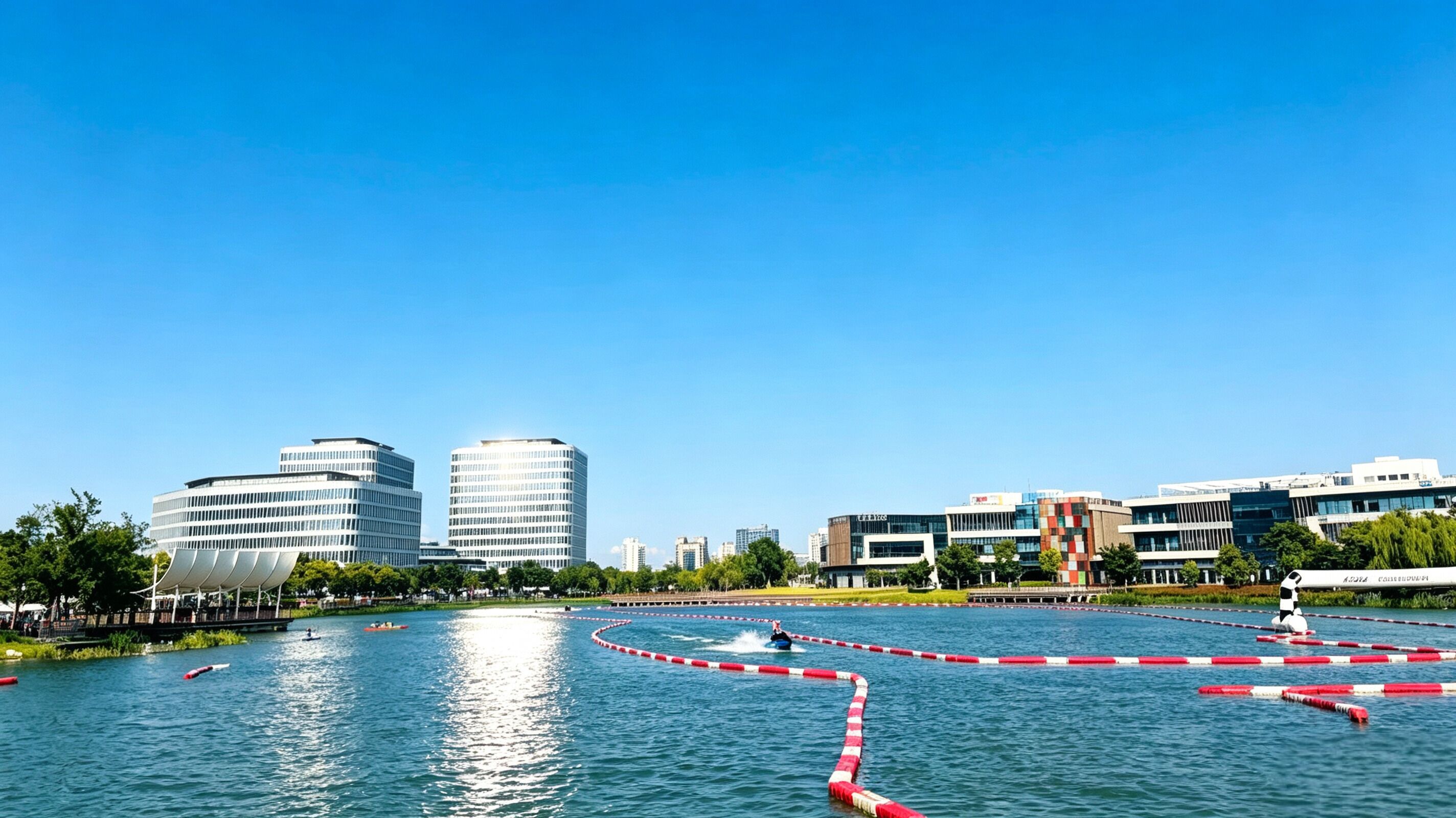 Een rivier met een rode en witte afscheiding, omringd door moderne gebouwen en begroeiing.