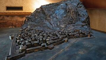 Une maquette détaillée d’une ville historique, avec une colline imposante et les bâtiments qui l’entourent.