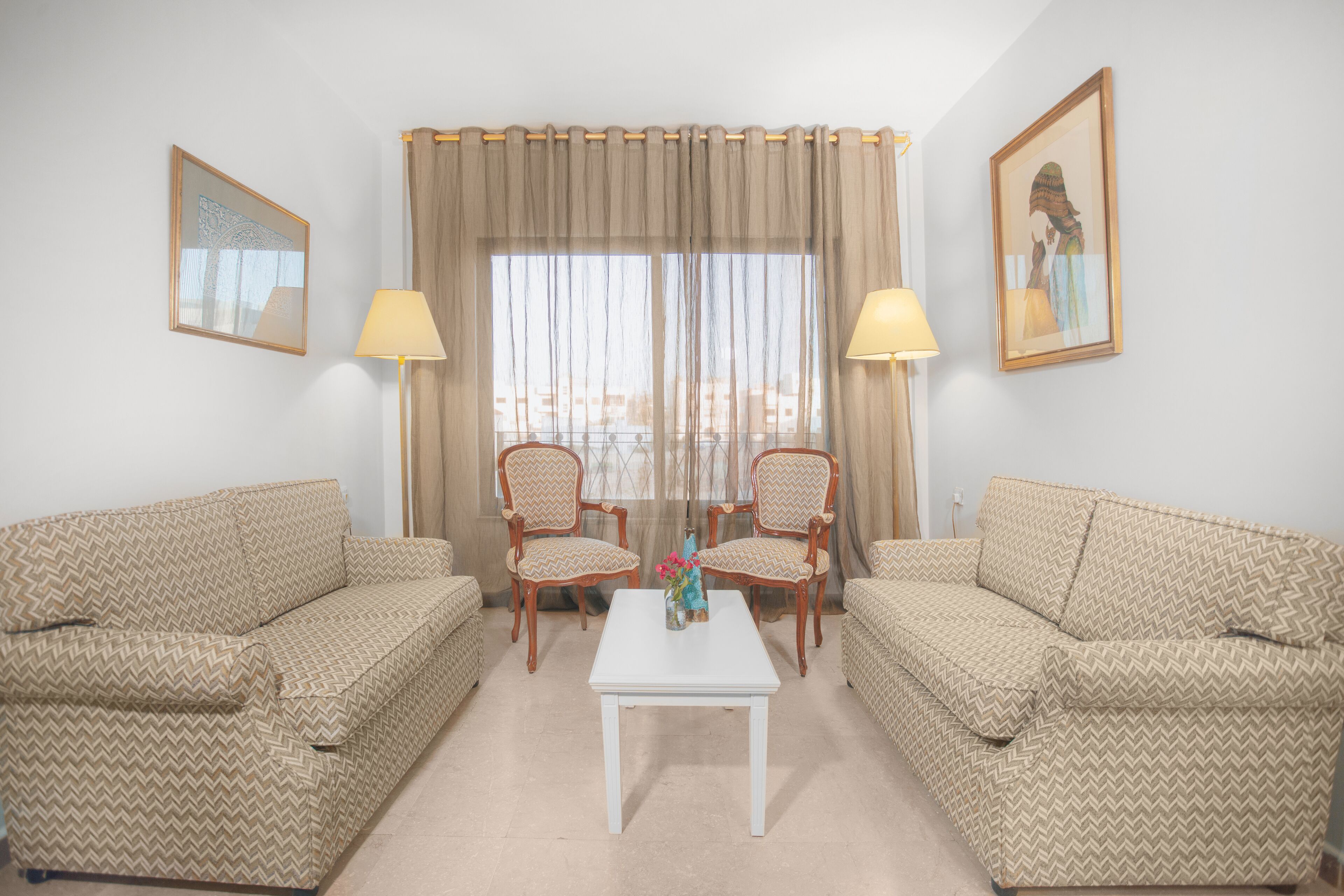 Ein Wohnzimmer mit zwei Sofas, einem Couchtisch und zwei Lampen.