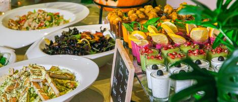 A buffet table with various dishes and drinks, including a pumpkin decoration.