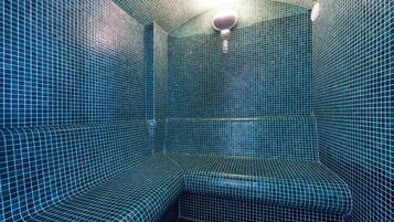 Cozy seating area with a bench and wall-mounted light fixture, set amidst a distinctive blue-tiled design.