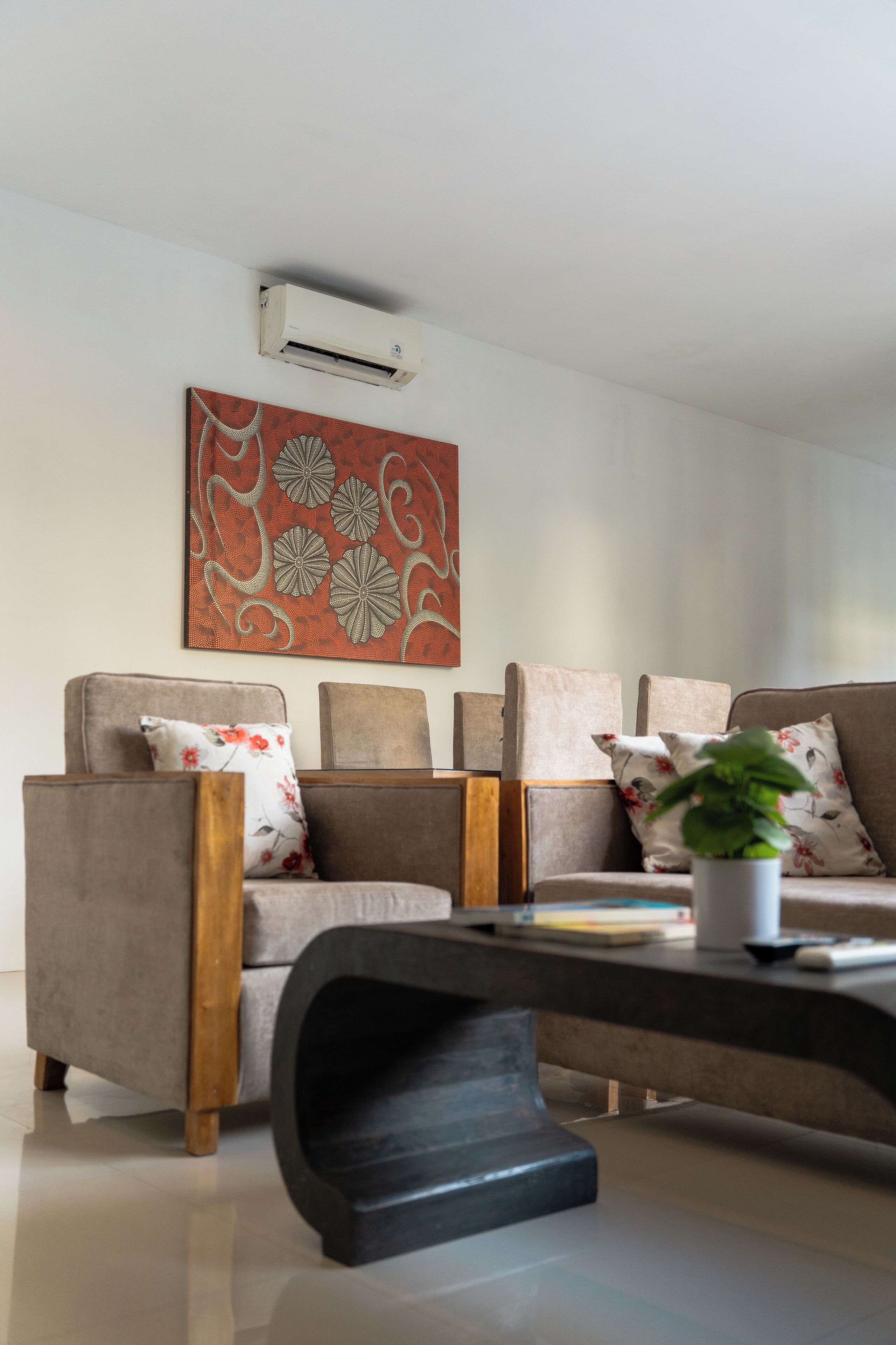 A modern living room with a sofa set, a coffee table, and a decorative wall piece.