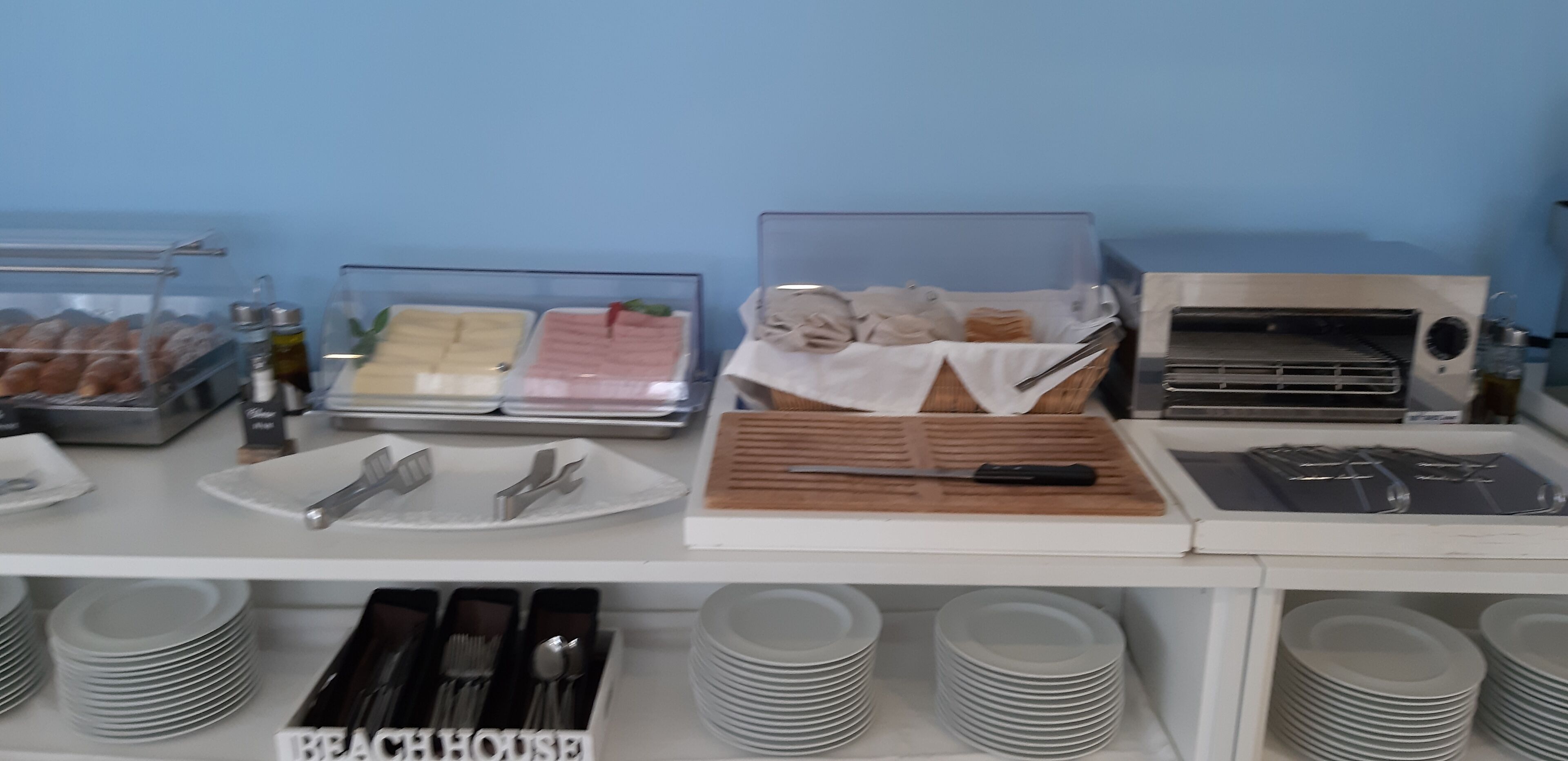 Un bufé de desayuno con diversos alimentos, utensilios y una máquina de café.
