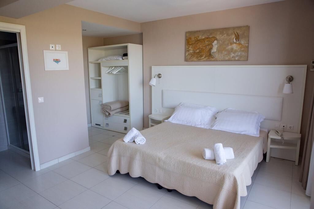 Une chambre d’hôtel avec un grand lit, une armoire et un tableau au mur.
