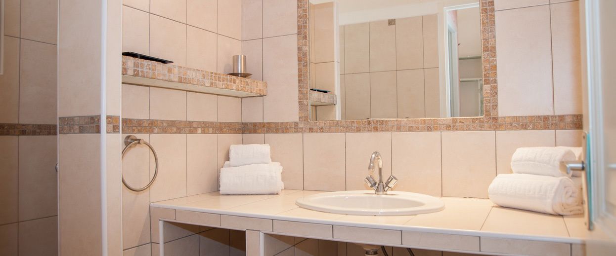 Une salle de bain avec deux lavabos, un miroir et un porte-serviettes.