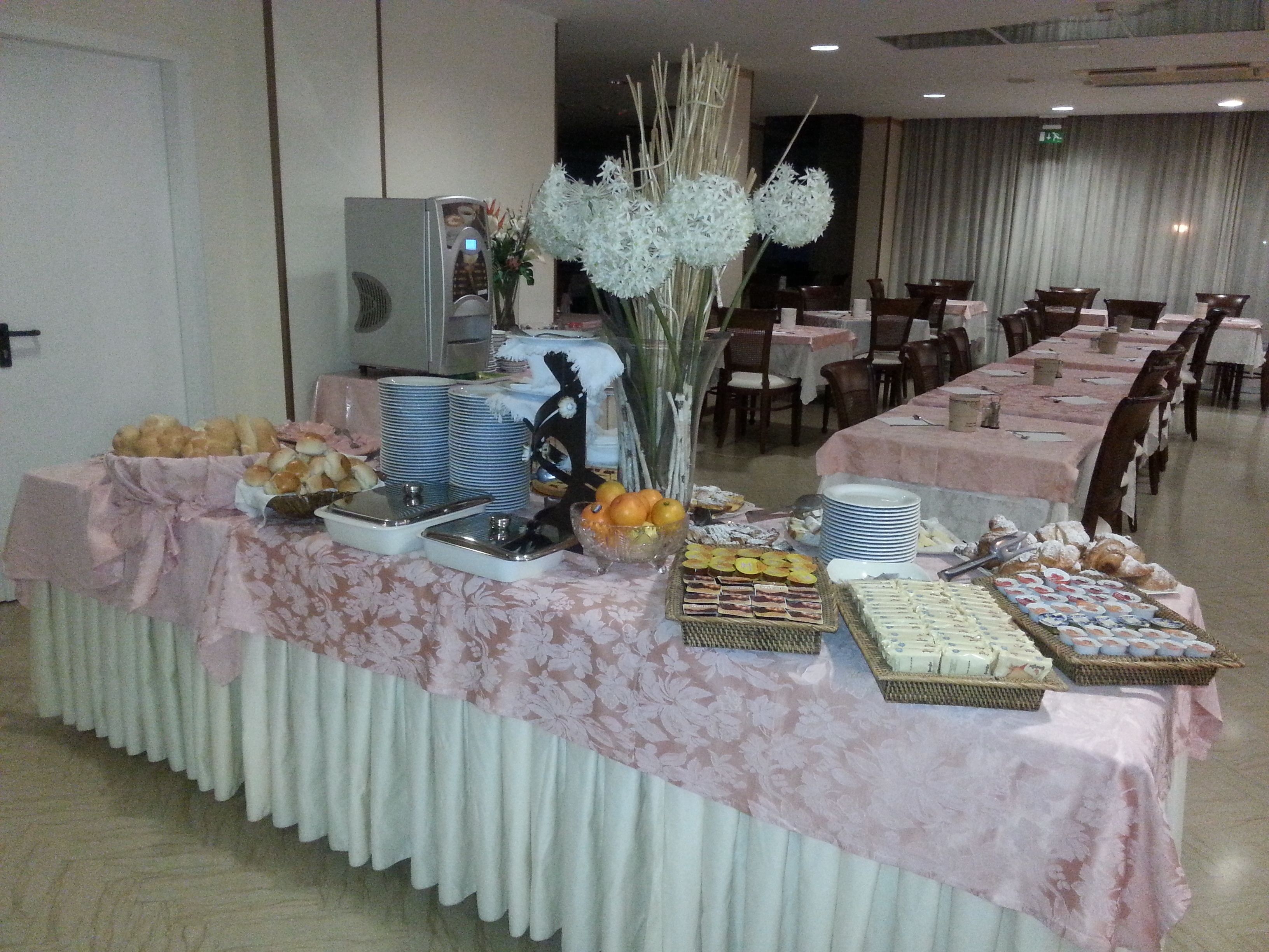 A buffet table with various food items and a decorative vase.