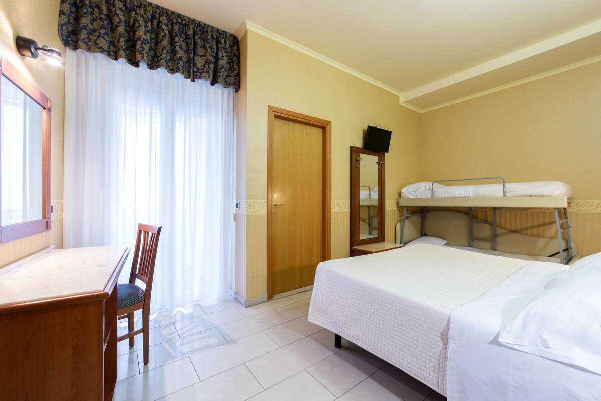 Una habitación de hotel con cama, escritorio y silla.