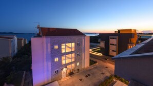 A multi-story building with a stone facade, large windows, and a flat roof. - Sunset Beach Suites (Zadar)