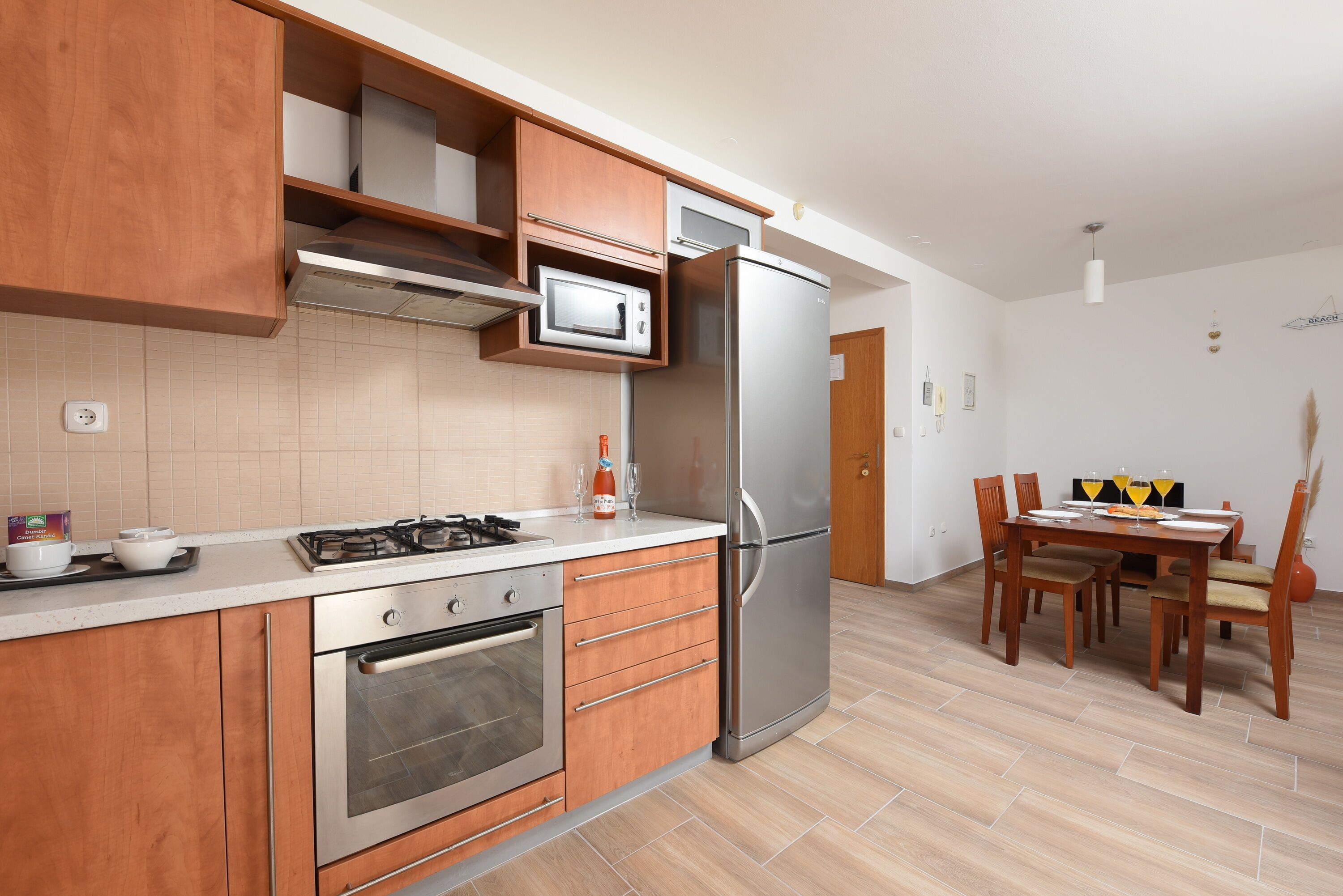 A modern kitchen with a built-in oven, microwave, and stainless steel refrigerator.