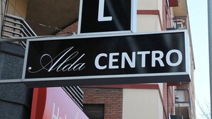 Letrero de un albergue con la palabra 'HOSTEL' y 'Alda Centro' escritas.