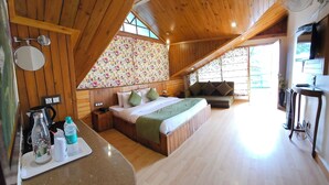 Ein gemütliches Holzhaus mit Schlafzimmer auf dem Dachboden, einer Küchenzeile und einem Wohnbereich mit Blick ins Freie.