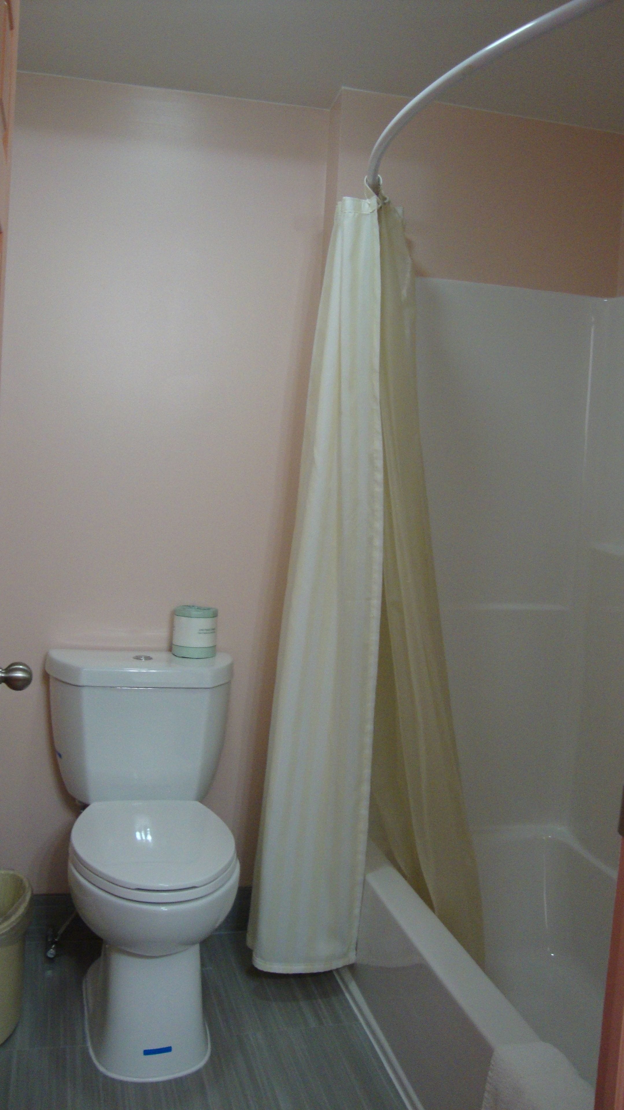 Un baño con inodoro, cortina de ducha y bañera.