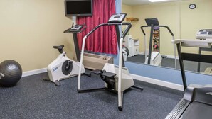 Ett gym med träningsutrustning, inklusive löpband, motionscykel och crosstrainer.
