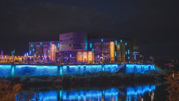 Un edificio moderno con señalización iluminada y vistas al agua.