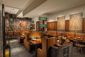 A modern restaurant with wooden accents, high tables, and booths.
