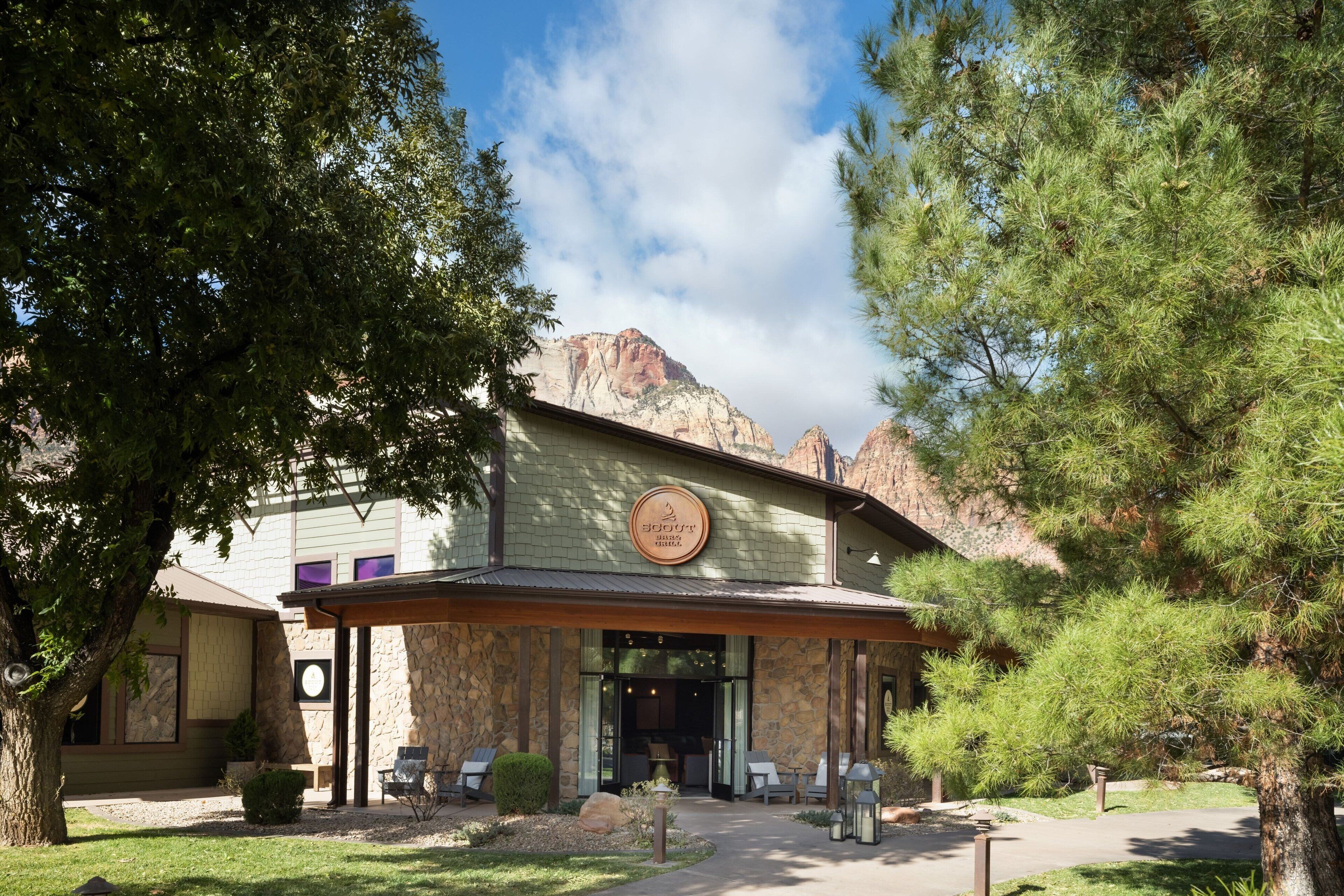 A building with a stone facade, a covered entrance, and outdoor seating.