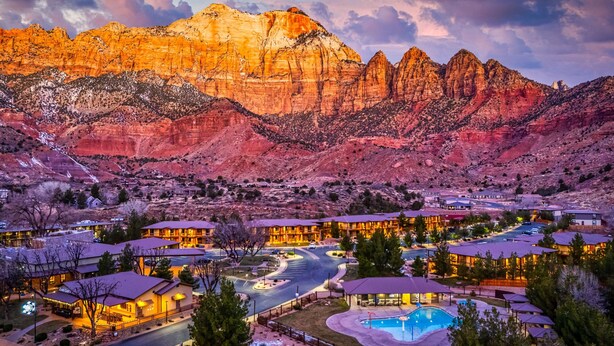 A resort with multiple buildings, a swimming pool, and a mountainous backdrop. - Red Cliffs Lodge Zion, A Tribute Portfolio Hotel - Marriott Bonvoy (Springdale)