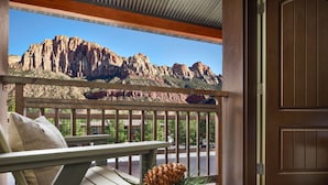 A wooden chair with a pine cone and greenery on a balcony with a view of a mountain range. - Red Cliffs Lodge Zion, A Tribute Portfolio Hotel - Marriott Bonvoy (Springdale)