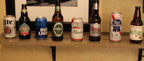 A shelf with various beer cans and bottles.
