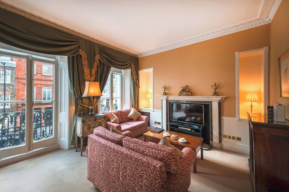 Een woonkamer met een open haard, een bank en een televisie.