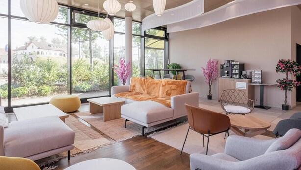 A modern interior with a sofa, chairs, a coffee table, and a cabinet with decorative items. - Prize by Radisson, Zurich Affoltern am Albis (Affoltern am Albis)
