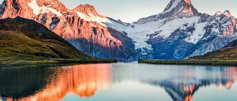 A mountain landscape with a calm lake reflecting the peaks.
