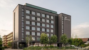 A modern hotel building with a dark facade, multiple windows, and a visible logo on the side. - Prize by Radisson, Zurich Affoltern am Albis (Affoltern am Albis)