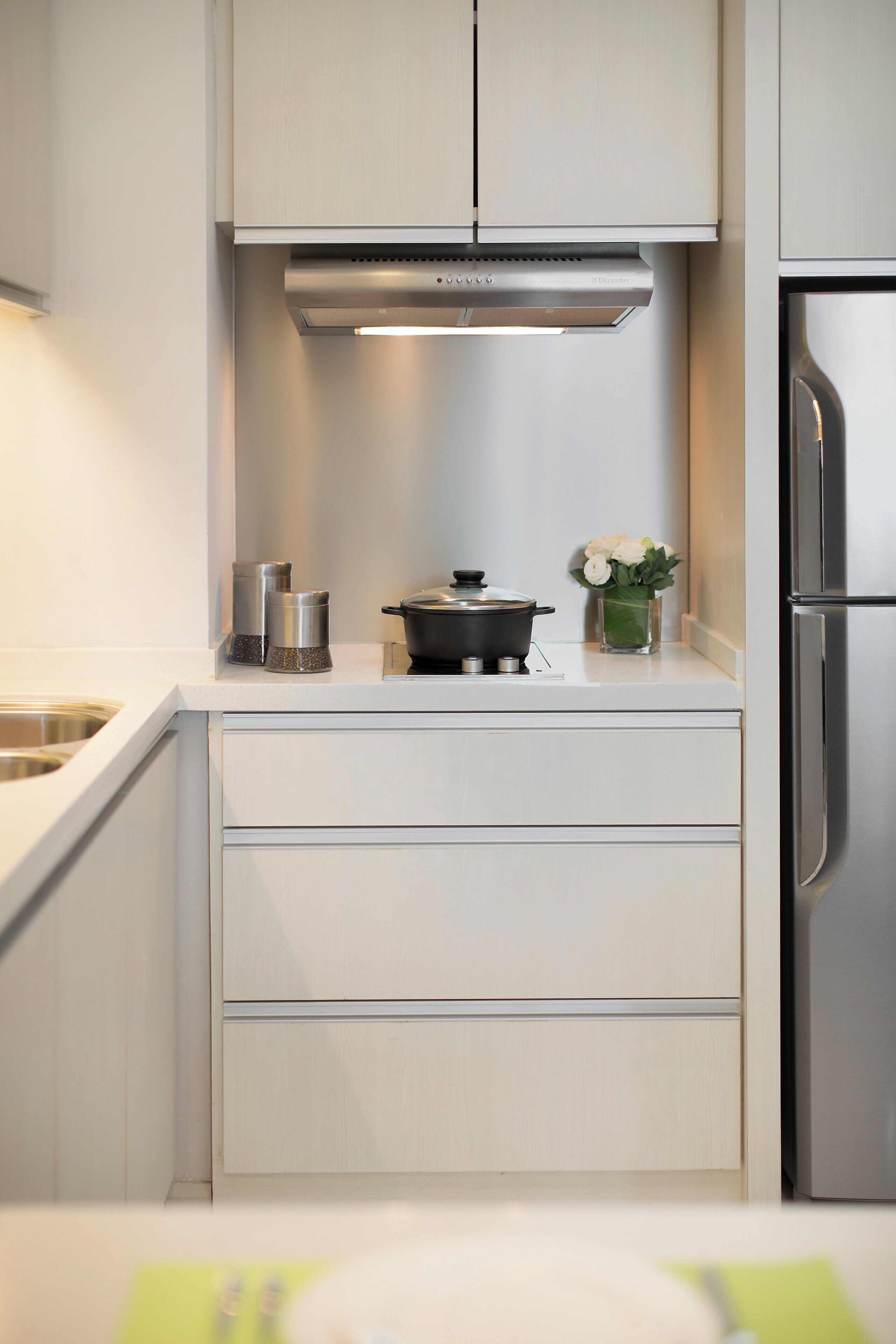 A modern kitchen with white cabinetry, stainless steel appliances, and a small countertop area.