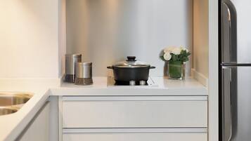 A modern kitchen with white cabinetry, stainless steel appliances, and a small countertop area.