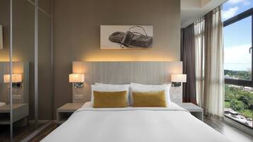 Une chambre d’hôtel moderne avec un grand lit, deux lampes de chevet, une œuvre d’art accrochée au mur et une vue sur la ville grâce à de grandes fenêtres.